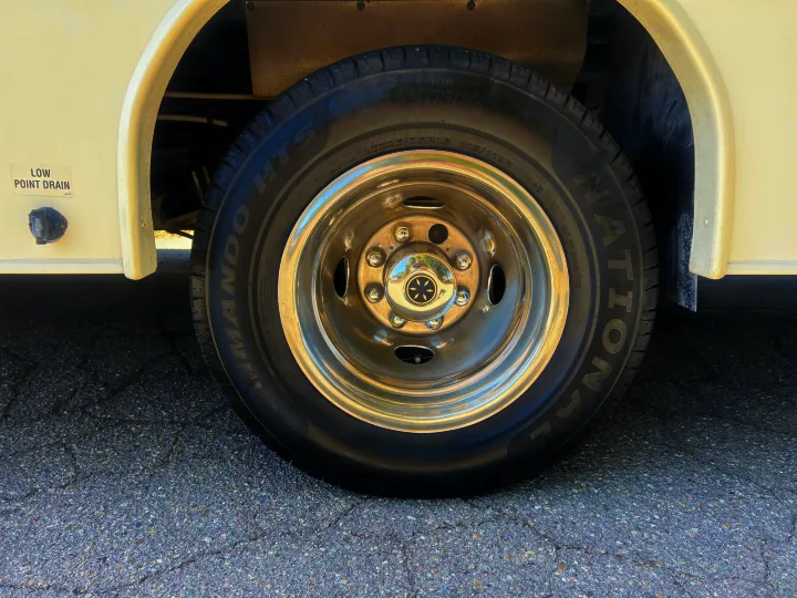 RV rental detail: shiny wheel, National Commando HTS LT225/75R16 tire, and "Low Point Drain" on the camper side.. Jayco Greyhawk 2016