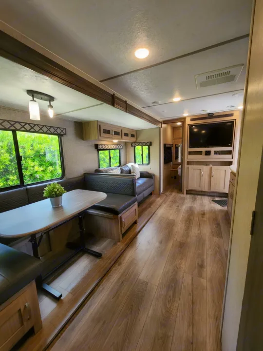 Explore this clean & spacious RV rental living area with dinette, sofa, TV, and stylish wood-look flooring.. Coachmen 292BHDS 2021