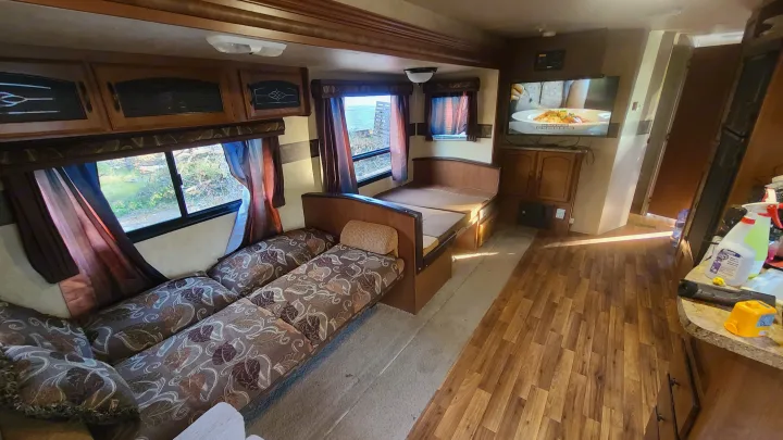 RV rental interior: Comfortable living area with dinette seating, large windows, TV, and kitchen counter.. Coachmen salem 2013