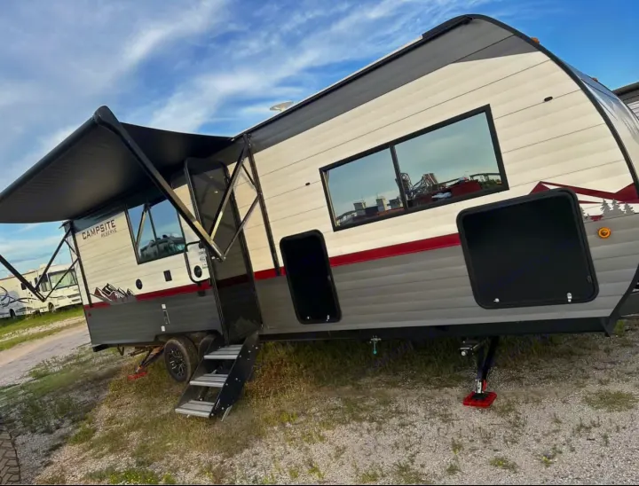 Explore the outdoors with this travel trailer RV rental, featuring an extended awning and deployed steps.. Forest River Campsite reserve 25MW 2024