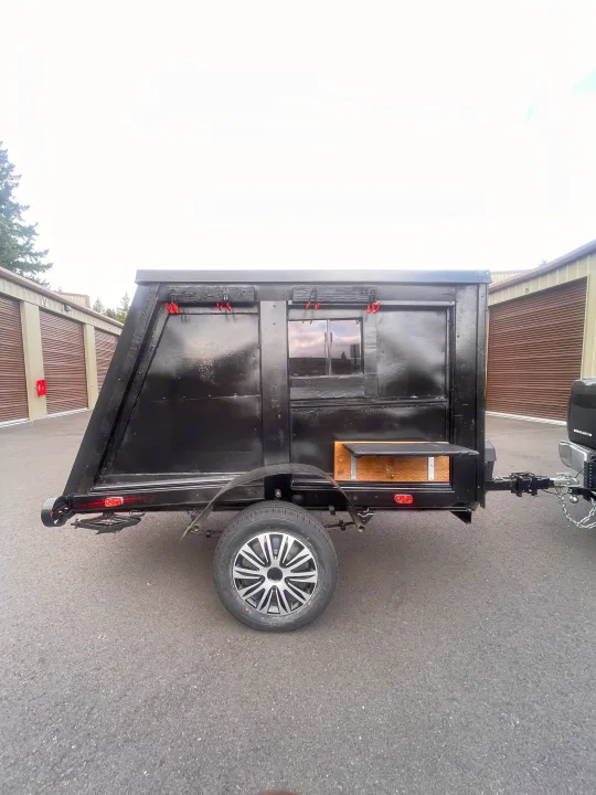 This black, custom-built camping trailer, ideal for unique rv rental experiences, features a window and outdoor shelf.. Custom Squaredrop Trailer 2020