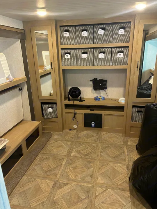 Functional RV rental bedroom with bunk beds, custom storage, and labeled bins for an organized travel experience.. Forest River Wildwood 2024