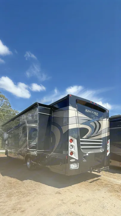 Sleek black Encore RV, an excellent rv rental option, parked under a bright blue sky. Ready for memorable journeys.. Coachmen Encore 2022