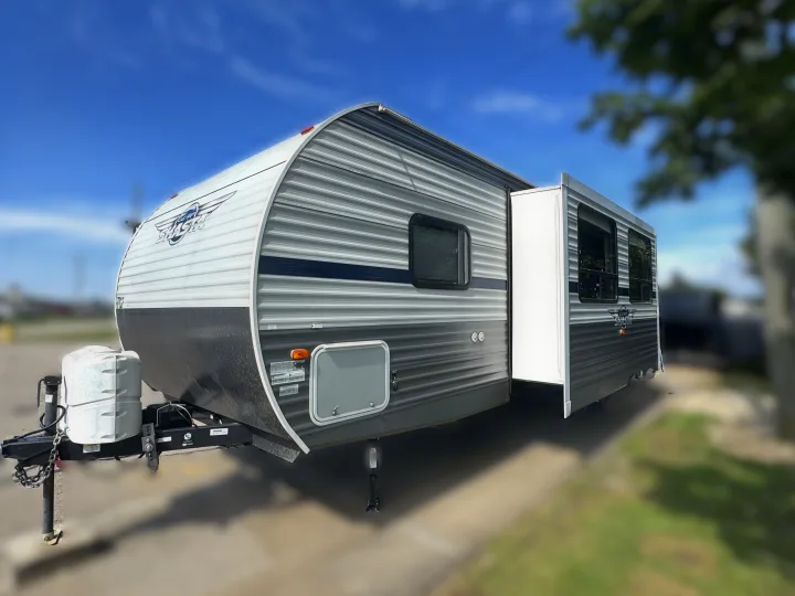 This grey and white Shasta travel trailer RV rental features a convenient slide-out, ready for your next trip.. Forest River Shasta 26DB 2020