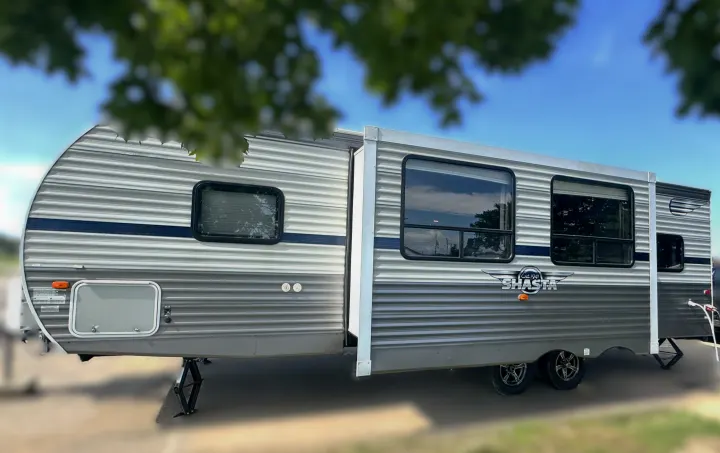 Spacious Shasta RV rental parked at a sunny campsite, slide-out extended, ready for a comfortable travel or camping vacation.. Forest River Shasta 26DB 2020