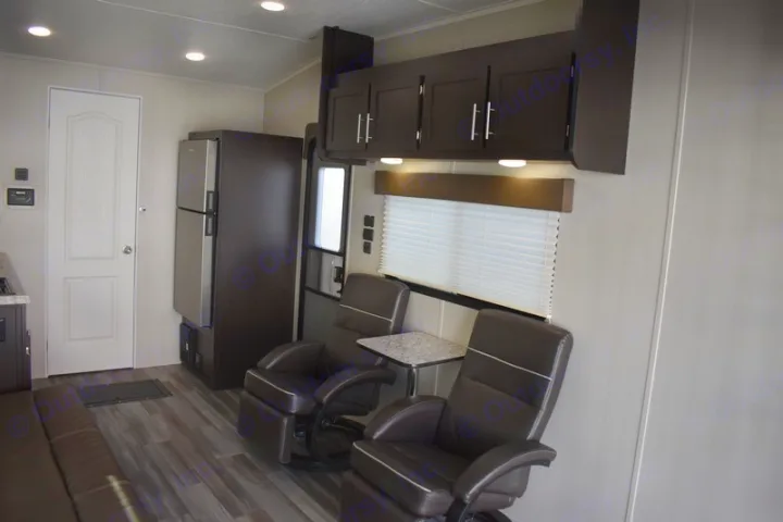 Inside this comfy RV rental: dark recliners, fridge, overhead cabinets, and a door for your travel comfort.. Dune Sport Dynamite 2023