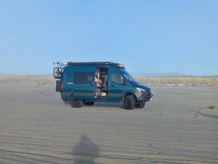 This teal adventure van, an ideal RV rental, is perfectly set up for beach camping with its bike and roof lights.. Mercedes-Benz Sprinter 2025