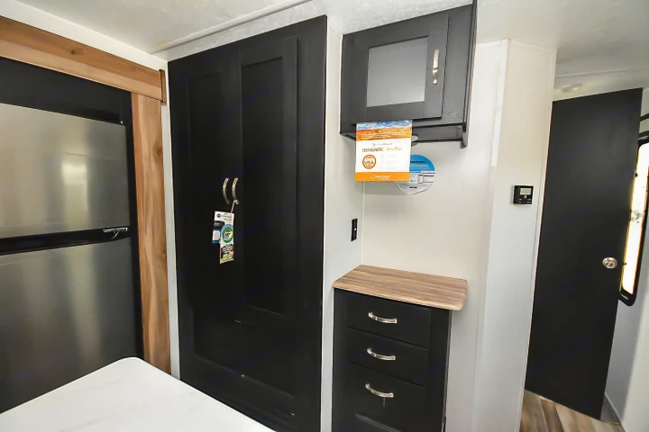 Stylish RV rental kitchen interior featuring a stainless fridge, dark cabinets, and a functional counter space.. Coachmen Coachmen Freedom Express Liberty Edition (324RLDSLE) 2022
