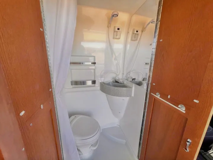 RV rental compact wet bath: a functional space featuring a toilet, small sink, and shower within a single enclosure.. Roadtrek Roadtrek Class B 2017