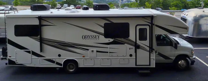 A full side view of a white Odyssey Entegra Class C RV rental, perfect for your next travel adventure.. Entegra Coach Odyssey 2024