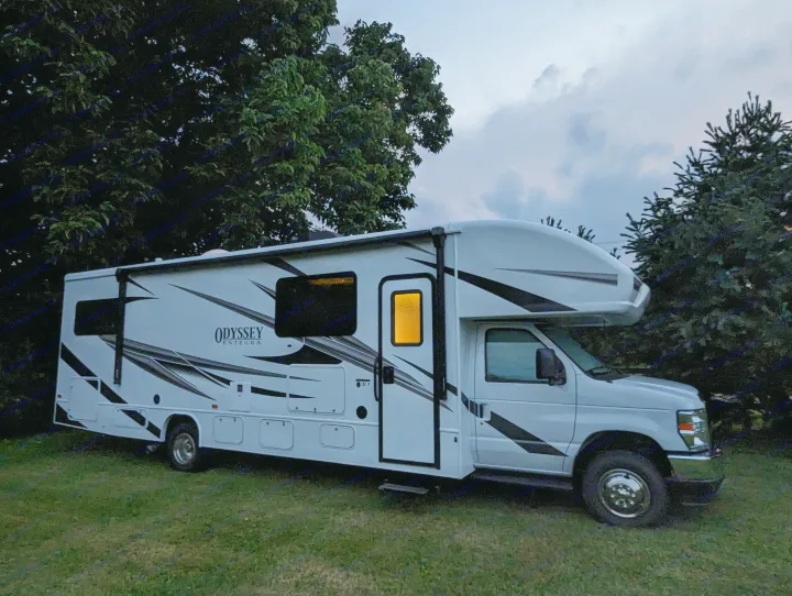 This white Odyssey Entegra motorhome RV rental is illuminated at dusk, ready for your next outdoor camping adventure.. Entegra Coach Odyssey 2024