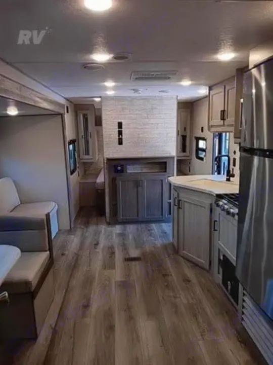 Bright RV rental interior featuring a modern kitchen, cozy living area, and light wood-look flooring. Ready for your adventure.. Other Catalina 2025