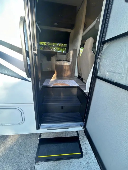 Step inside this cozy RV rental! View of the open door, interior steps, dining area, and outdoor step.. Entegra Ford Transit 2025