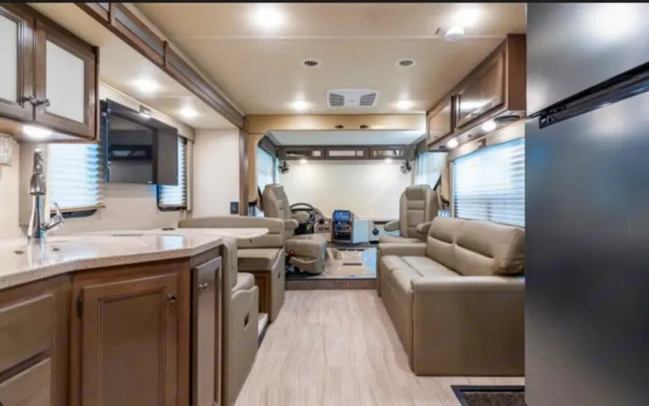 Spacious RV rental interior featuring a modern kitchenette, living area, and driver's cockpit. Perfect for road trips.. Thor Windsport 2023