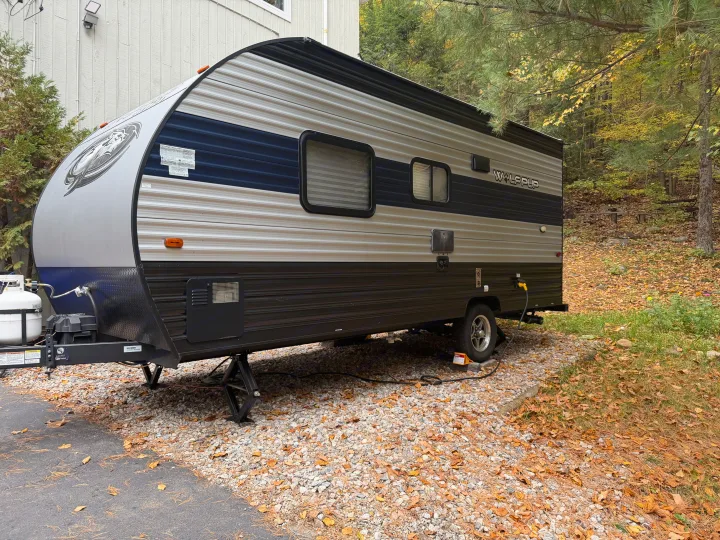 This RV rental, a Wolf Pup travel trailer, is parked on gravel, ready for adventure amidst fall foliage.. Forest River Cherokee Wolf Pup 2021