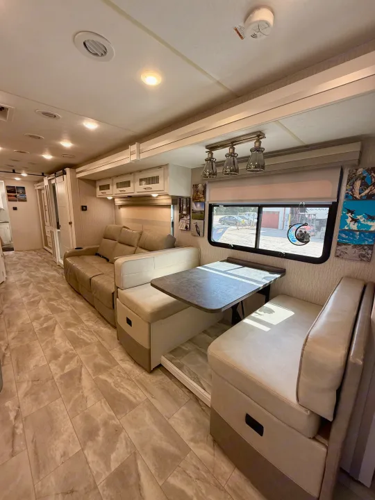 Step inside this inviting RV rental, featuring a cozy dinette, plush recliners, and modern tiled flooring.. Coachmen Encore 2022