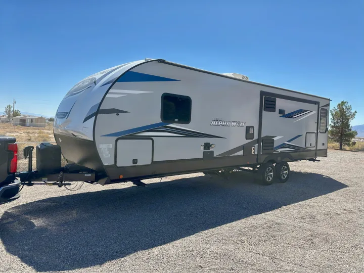 Experience freedom with this Alpha Wolf travel trailer RV rental, parked under a clear sky for your next adventure.. Forest River Cherokee Alpha Wolf 2021