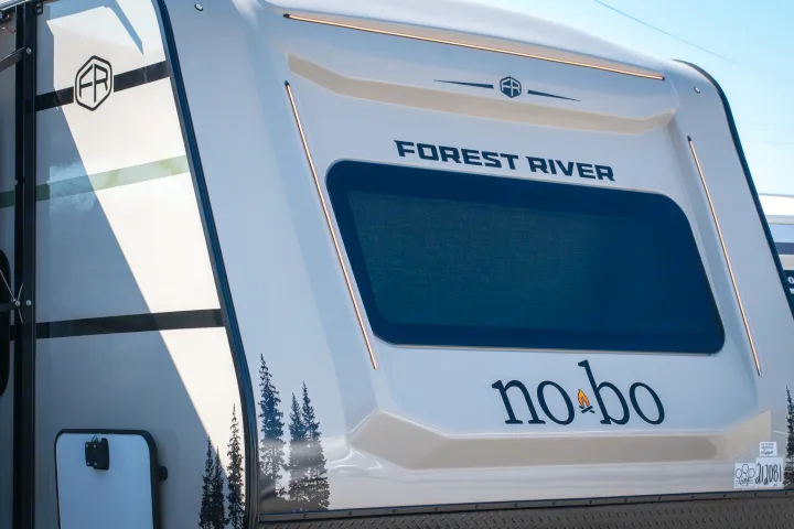 Front of a Forest River no bo RV, featuring its window, LED lights, and tree decals. Ideal for an RV rental.. Forest River No Boundaries 2026