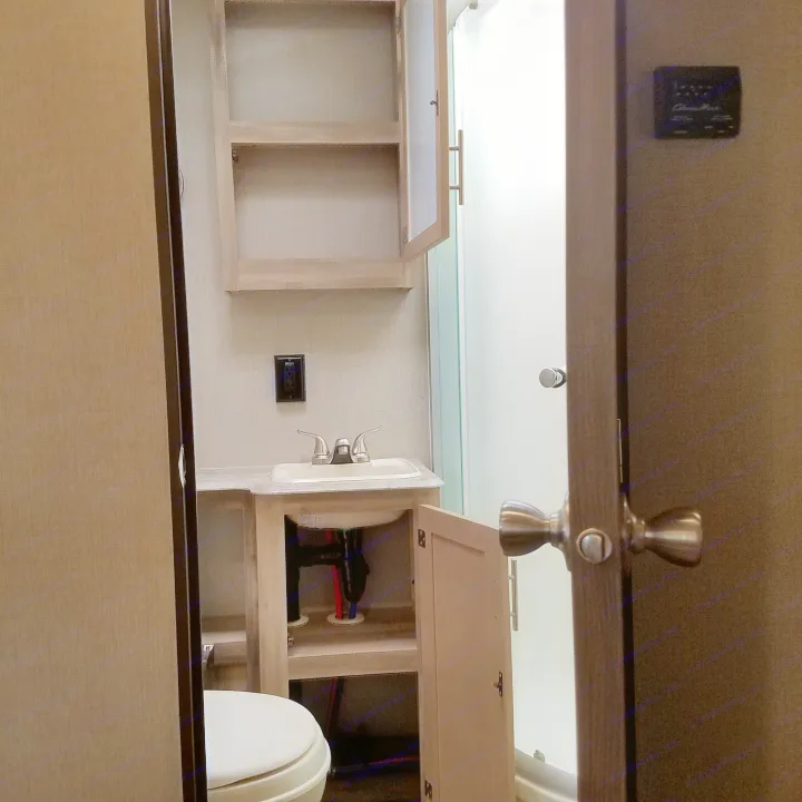 This RV rental bathroom offers a compact vanity, sink, toilet, shower, and medicine cabinet in a cozy, functional space.. Coachmen Catalina 2021