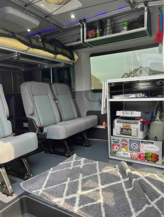 RV rental: well-equipped van interior with seating, overhead bunk, and fridge. Perfect for travel & camping adventures.. Ford Transit 2018