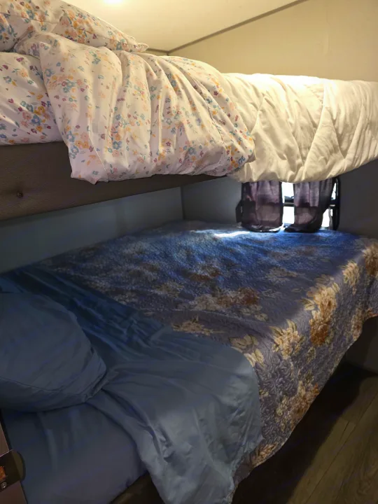 RV rental bunk beds: Floral duvet on top, blue sheet & quilted floral spread on bottom bunk. Perfect for family.. Coachmen Catalina Legacy 2024