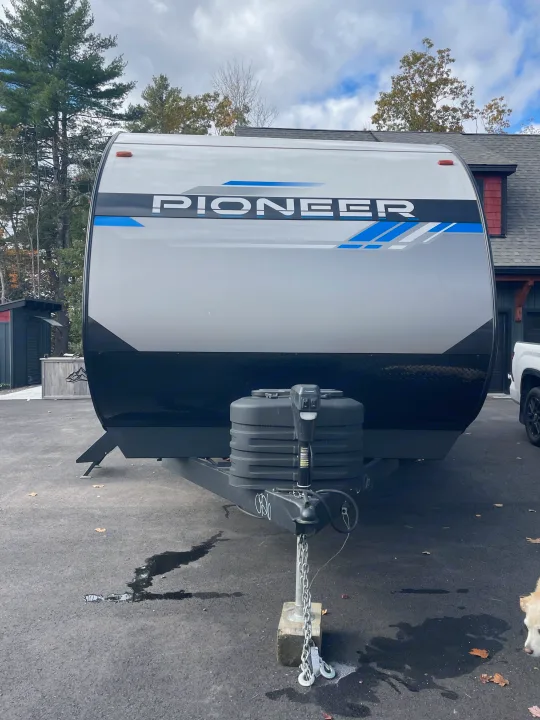 Front view of a grey and black Pioneer travel trailer RV rental, parked for your next camping or road trip adventure.. Heartland Pioneer 2024