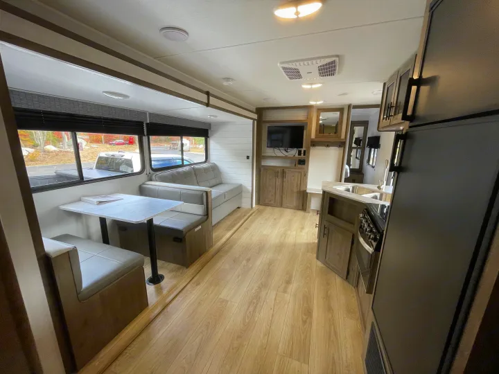 Spacious RV rental interior with modern kitchen, dinette, sofa, and light wood flooring, perfect for a cozy trip.. Heartland Pioneer 2024
