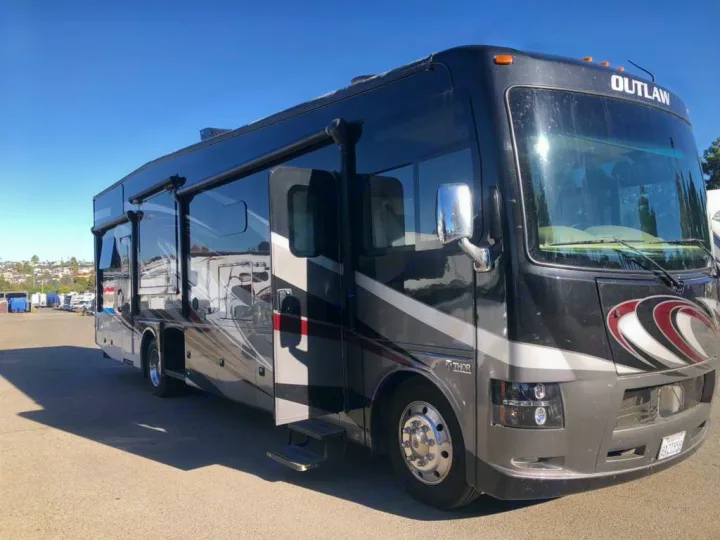 Luxurious black Thor Outlaw Class A RV rental, parked outdoors on a sunny day, ready for your next adventure.. Thor Outlaw 2017