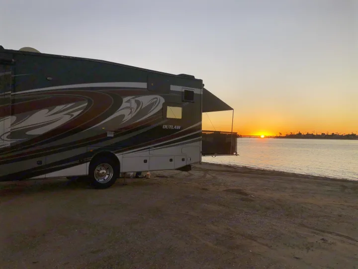 Outlaw RV rental parked beachfront for a gorgeous sunset. Motorhome by the water with extended awning.. Thor Outlaw 2017