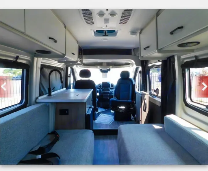 Inside a sleek rv rental camper van: kitchen sink, cushioned seating, and overhead cabinets for storage. Ready for adventure!. thor Sequence 2026