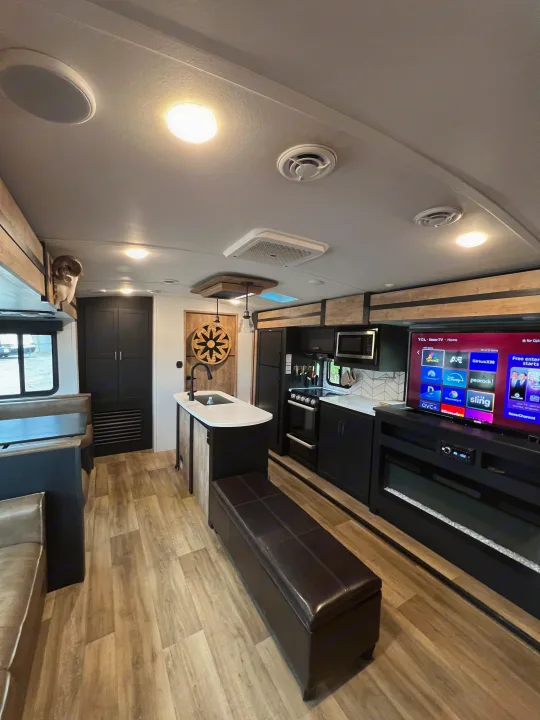 This RV rental offers a modern interior, featuring a full kitchen, dining booth, TV, and cozy fireplace for your adventures.. Keystone RV Outback 2022