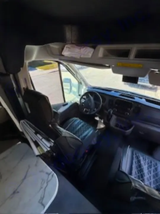 RV rental interior: A spacious view from the living area into the front cockpit, featuring the driver's seat and dashboard.. Forest River Coachmen Cross Trek 2021