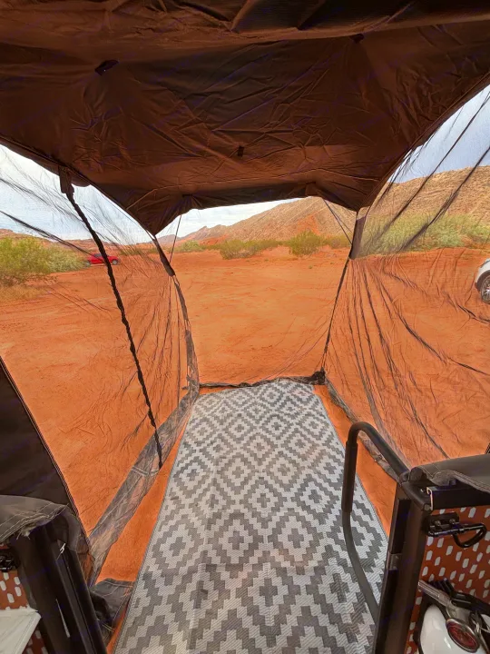 Enjoying a desert view from an RV rental's screened annex, featuring a patterned mat and vast landscape.. Forest River Viking TD 2022
