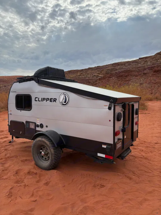 Adventure awaits with this Clipper RV rental camper in a stunning red rock desert under cloudy skies.. Forest River Viking TD 2022