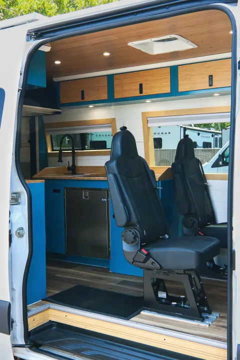 Explore this custom rv rental interior! Featuring a compact kitchen, adjustable passenger seating, and a modern design.. Mercedes-Benz Sprinter 2024