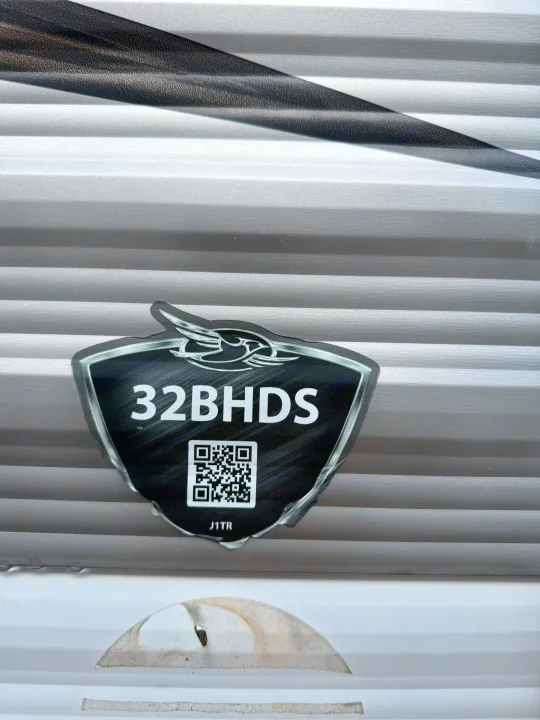 RV rental model 32BHDS emblem with a QR code on a corrugated silver side panel, for travel trailer info.. Jayco Jay Flight 2018