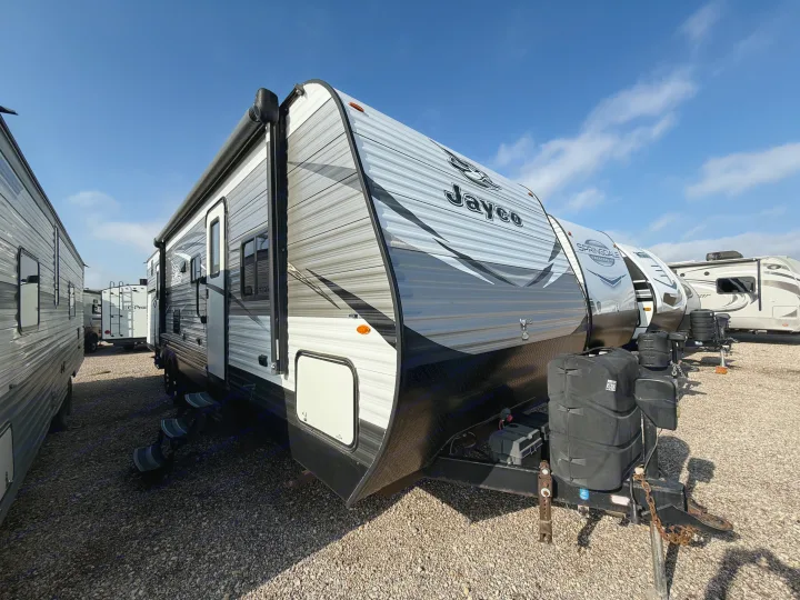 Discover this Jayco travel trailer, perfect for your next RV rental. It's parked outdoors, featuring grey/white siding and a robust hitch.. Jayco Jay Flight 2018