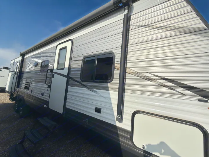 Modern Jay Flight travel trailer RV rental with sleek gray and white striped exterior and awning.. Jayco Jay Flight 2018