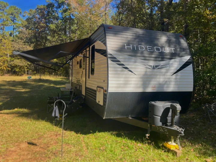 This Hideout travel trailer is an RV rental set up in a peaceful, wooded campsite for your next outdoor adventure.. Keystone RV Hideout 2021