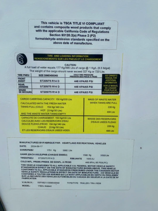 RV rental info label: TSCA compliant, listing tire sizes, pressures (65 PSI), cargo, and water tank weights for a 17BHL Mallard.. Heartland RVs Mallard 2025