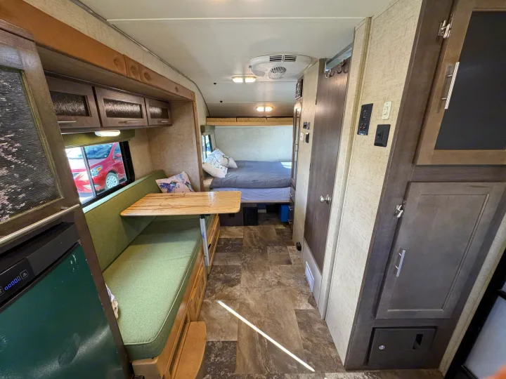 Inside this RV rental: a dinette with Lagun table, comfy bed, and various amenities, ready for your next adventure.. R-Pod Hood River Edition 2015