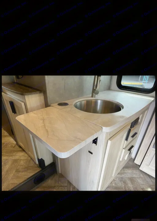 Modern RV rental kitchen with stainless sink, extendable counter, and light wood cabinets. Enjoy extra space while traveling!. Forester LE 2023