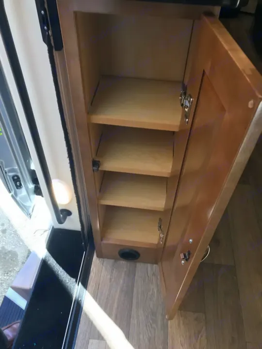 Open storage cabinet with shelves inside an rv rental, showing organized interior space and a floor vent.. Coachmen Galleria 2020