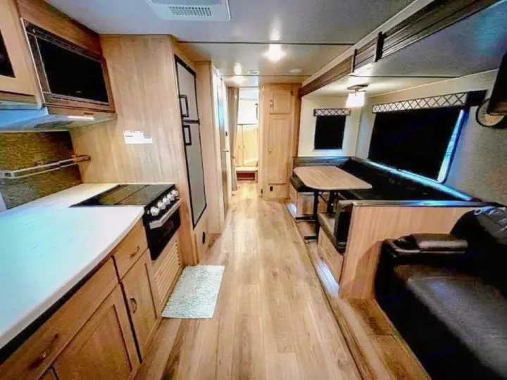 Interior of an RV rental: full kitchen with stove & microwave, dinette, and living area with comfortable seating and wood floors.. Coachmen Other 2020