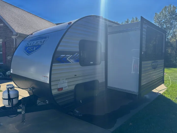 Salem FSX toy hauler travel trailer, ideal for rv rental, featuring an open rear ramp door and front propane tank.. Forest River Salem FSX 2022