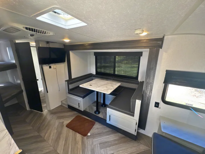 Bright rv rental interior, showing a comfy dinette with storage, bunk beds, and a sleek design ready for your next trip.. Forest River Salem FSX 2022