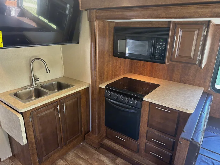 RV rental kitchen: double sink, microwave, oven, and various storage cabinets, ready for your road trip meals.. Forest River FR3 2017