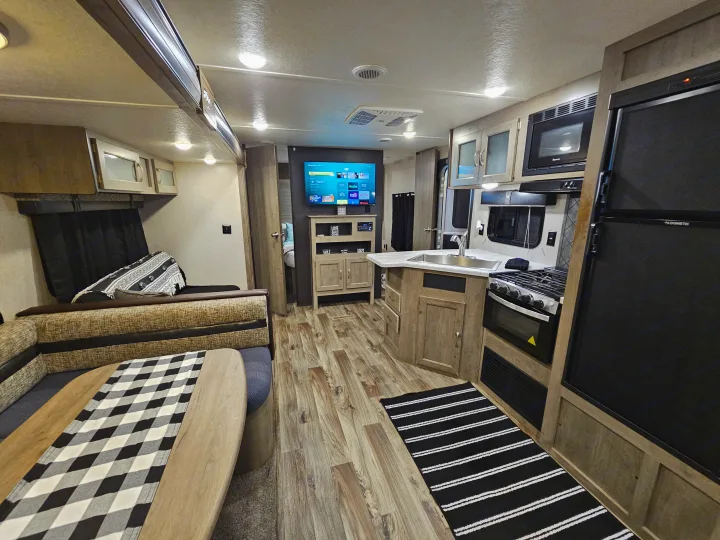 Step inside this modern rv rental, featuring a full kitchen, dinette, TV, and comfortable living space with wood-look floors.. Forest River Palomino Puma XLE 2019