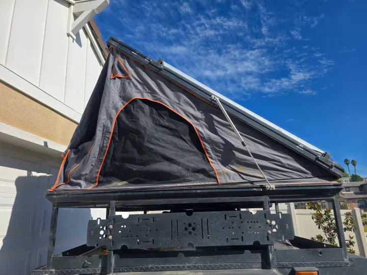 An open gray rooftop tent on an overland vehicle, ideal for an RV rental adventure under a clear blue sky.. Custom Build Offroad Trailer 2021