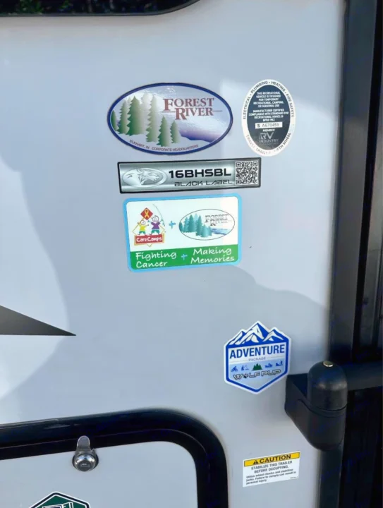 This RV rental's side panel shows Forest River, Wolf Pup, and model stickers, along with safety info, ideal for a travel trailer adventure.. Forest River Cherokee Wolf Pup 2023